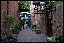 Couple walking in an alley of brick walls, San Pedro Square. San Jose, California, USA (color)