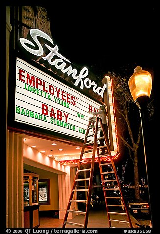 Woman on ladder arranging sign letters, Stanford Theater. Palo Alto,  California, USA (color)
