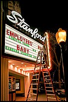 Woman on ladder arranging sign letters, Stanford Theater. Palo Alto,  California, USA