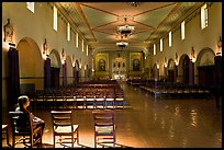 Woman sitting in chapel, Mission Santa Clara de Asis. Santa Clara,  California, USA (color)