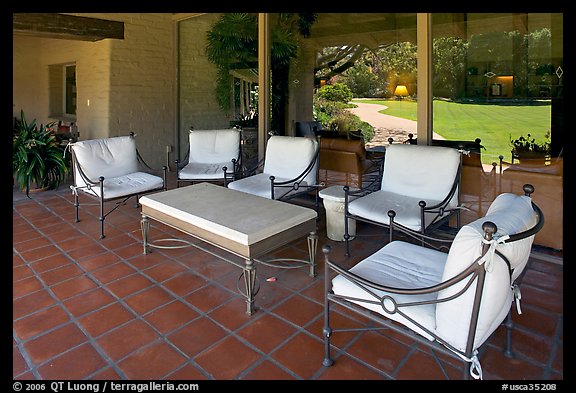 Chairs and coffee table on porch, Sunset gardens reflected. Menlo Park,  California, USA