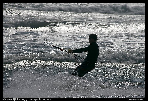 Kitesurfer silhouette against silvery water, Waddell Creek Beach. California, USA
