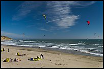 Kitesurfers rolling out sails on on beach, Waddell Creek Beach. California, USA