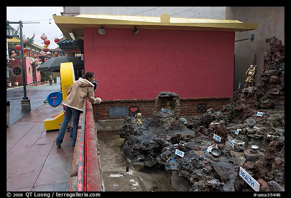 Woman at wishing well fountain, Chinatown. Los Angeles, California, USA