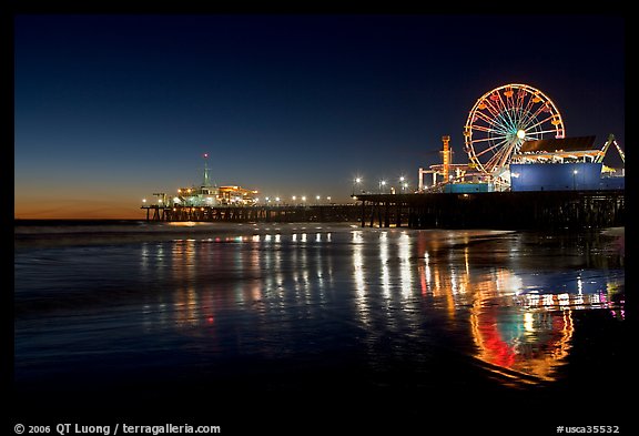 Ferris Wheel and pier reflected on wet sand at night. Santa Monica, Los Angeles, California, USA