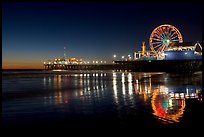 Ferris Wheel and pier reflected on wet sand at night. Santa Monica, Los Angeles, California, USA (color)