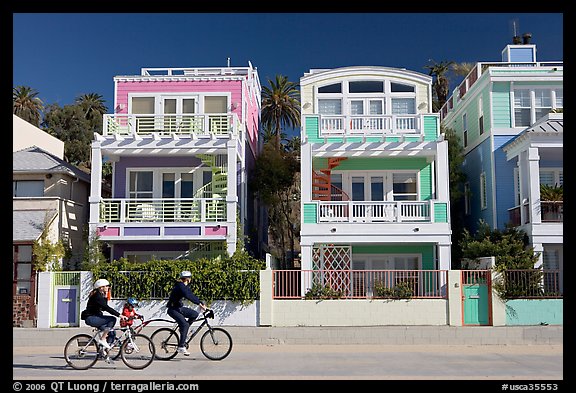 Family cycling in front of colorful beach houses. Santa Monica, Los Angeles, California, USA