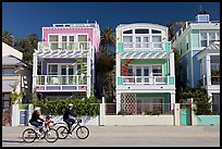 Family cycling in front of colorful beach houses. Santa Monica, Los Angeles, California, USA