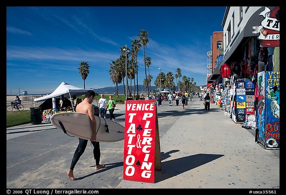 Surfer walking on Ocean Front Walk. Venice, Los Angeles, California, USA (color)