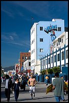 Jogger in the crowd of Ocean Front Walk, with a Venice Mural behind. Venice, Los Angeles, California, USA