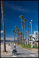 Woman riding a tricycle on the beach promenade. Venice, Los Angeles, California, USA