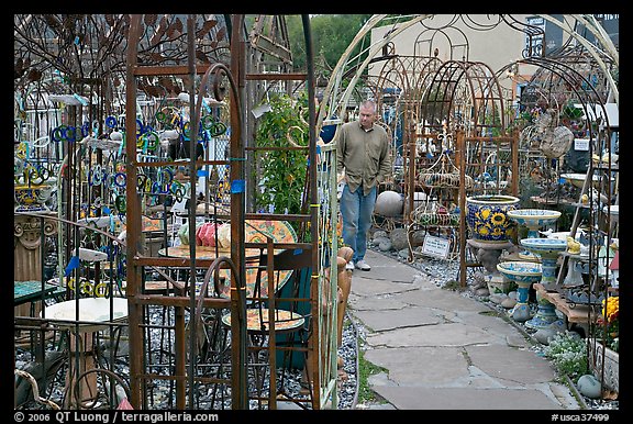 Man browsing in colorful outdoor antique display. Half Moon Bay, California, USA (color)