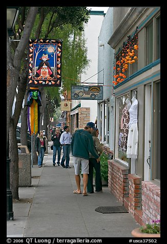 People looking at store display on Main Street. Half Moon Bay, California, USA (color)