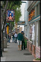 People looking at store display on Main Street. Half Moon Bay, California, USA (color)