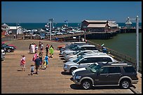 People drapped with colorful towels walking on wharf. Santa Barbara, California, USA ( color)