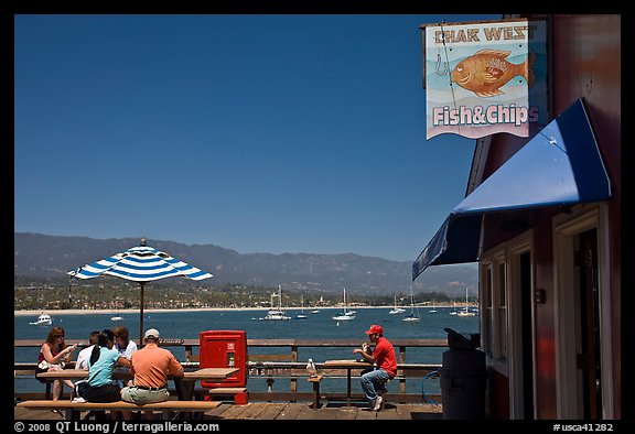 People eating with yachts and beach in background. Santa Barbara, California, USA