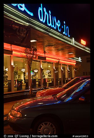 Neon lights of Mels drive-in reflected on parked cars. San Francisco, California, USA