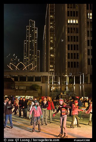 People skating on ice ring at night, Embarcadero Center. San Francisco, California, USA (color)