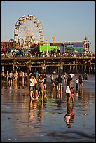 Pier and beachgoers reflected in wet sand, late afternoon. Santa Monica, Los Angeles, California, USA