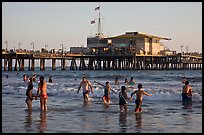 People bathing in ocean and Santa Monica Pier, late afternoon. Santa Monica, Los Angeles, California, USA (color)