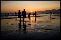 People and reflections on beach at sunset, Santa Monica Beach. Santa Monica, Los Angeles, California, USA