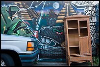 Car, mural, and discarded furniture, Mission District. San Francisco, California, USA