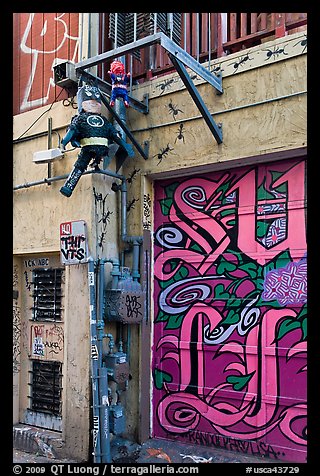 Painted garage door and suspended pinata figures, Mission District. San Francisco, California, USA