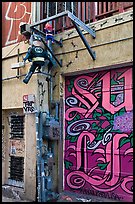 Painted garage door and suspended pinata figures, Mission District. San Francisco, California, USA