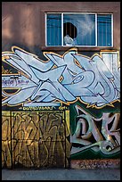 Mural paintings below broken window, Mission District. San Francisco, California, USA (color)