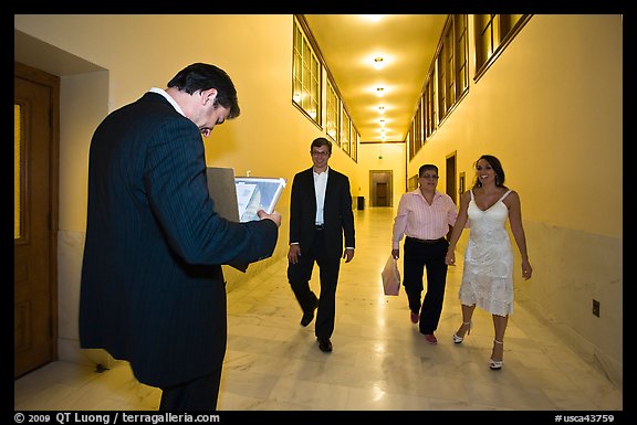 Soon to be maried couple and witness in City Hall corridor. San Francisco, California, USA