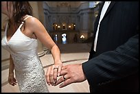 Newly wed couple holds hands, showing ring, City Hall. San Francisco, California, USA