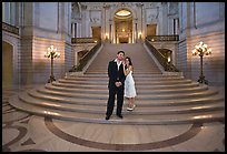 Just married couple at the base of the grand staircase, City Hall. San Francisco, California, USA (color)