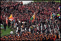 Academic flags exit amongst crow of graduates after commencement ceremony. Stanford University, California, USA (color)