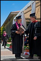 Graduate wearing lei presented with diploma. Stanford University, California, USA