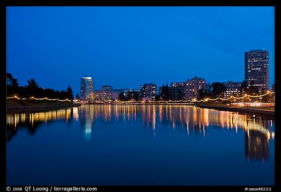 Oakland skyline reflected in Lake Meritt, twilight. Oakland, California, USA (color)