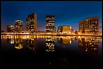 High-rise buildings and Oakland Cathedral reflected in Lake Meritt at night. Oakland, California, USA (color)