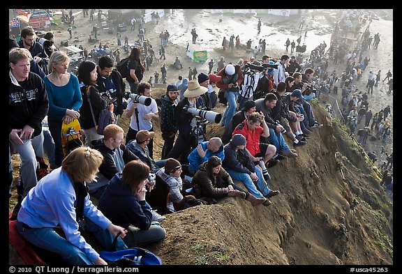 Spectators sitting on cliff to see mavericks contest. Half Moon Bay, California, USA (color)