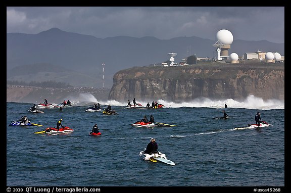 Flottila of personal watercraft near Mavericks break in front of  Pillar Point air force station. Half Moon Bay, California, USA (color)