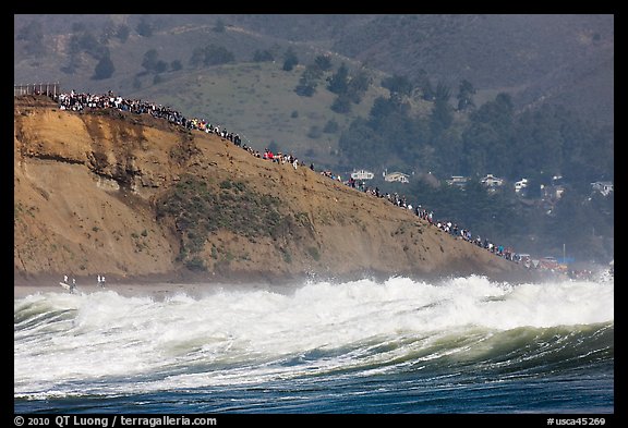 Bluff with spectators as seen from the ocean. Half Moon Bay, California, USA (color)