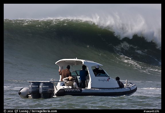 Small boat dwarfed by huge wave. Half Moon Bay, California, USA (color)