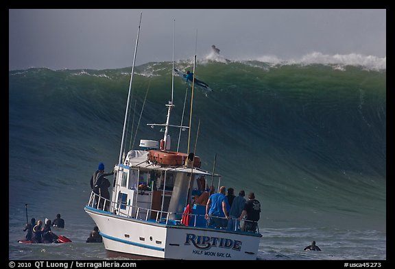 Judging boat with huge wave and surfer at crest. Half Moon Bay, California, USA