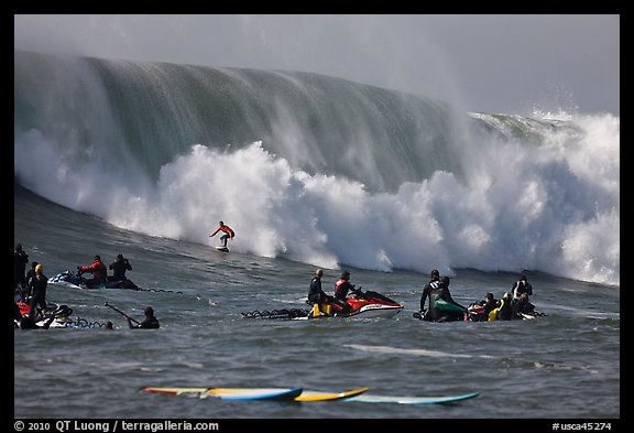 Waverunners and surfer in big wave. Half Moon Bay, California, USA (color)