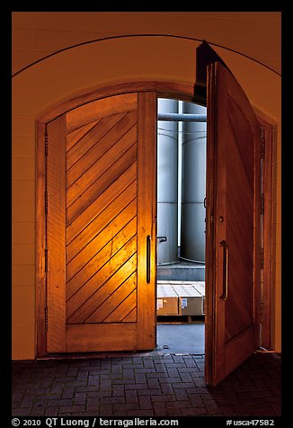 Wooden door opening to wine storage tanks. Napa Valley, California, USA