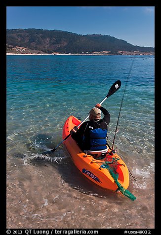 Sea kayaker with fishing rod in Carmel Bay. Carmel-by-the-Sea, California, USA