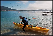 Man boards sea kayak, Carmel Bay. Carmel-by-the-Sea, California, USA (color)
