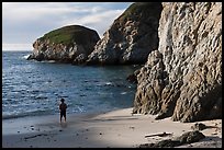 Boy standing at the base of bluff, China Cove. Point Lobos State Preserve, California, USA