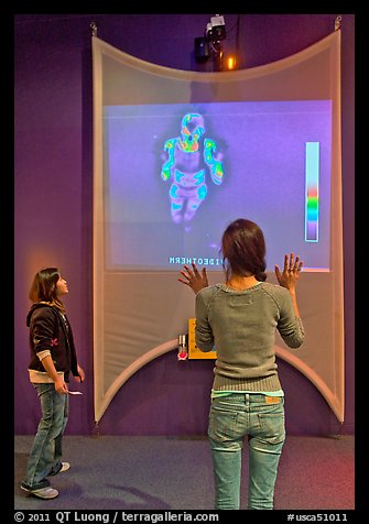 Girls play with thermal imaging camera, Tech Museum. San Jose, California, USA (color)