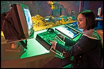 Woman controls robot, Tech Museum. San Jose, California, USA (color)