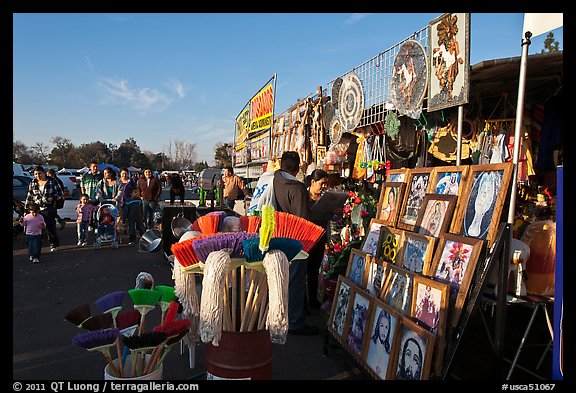 Brooms and religious pictures for sale, San Jose Flee Market. San Jose, California, USA (color)