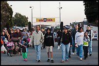 Families walking with entrance sign behind, San Jose Flee Market. San Jose, California, USA